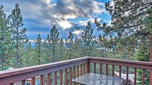 A wooden deck with a metal table and chairs, overlooking a forested area with tall pine trees. - 2 Mi to Heavenly Mountain: Tahoe Retreat w/ Views (Zephyr Cove)