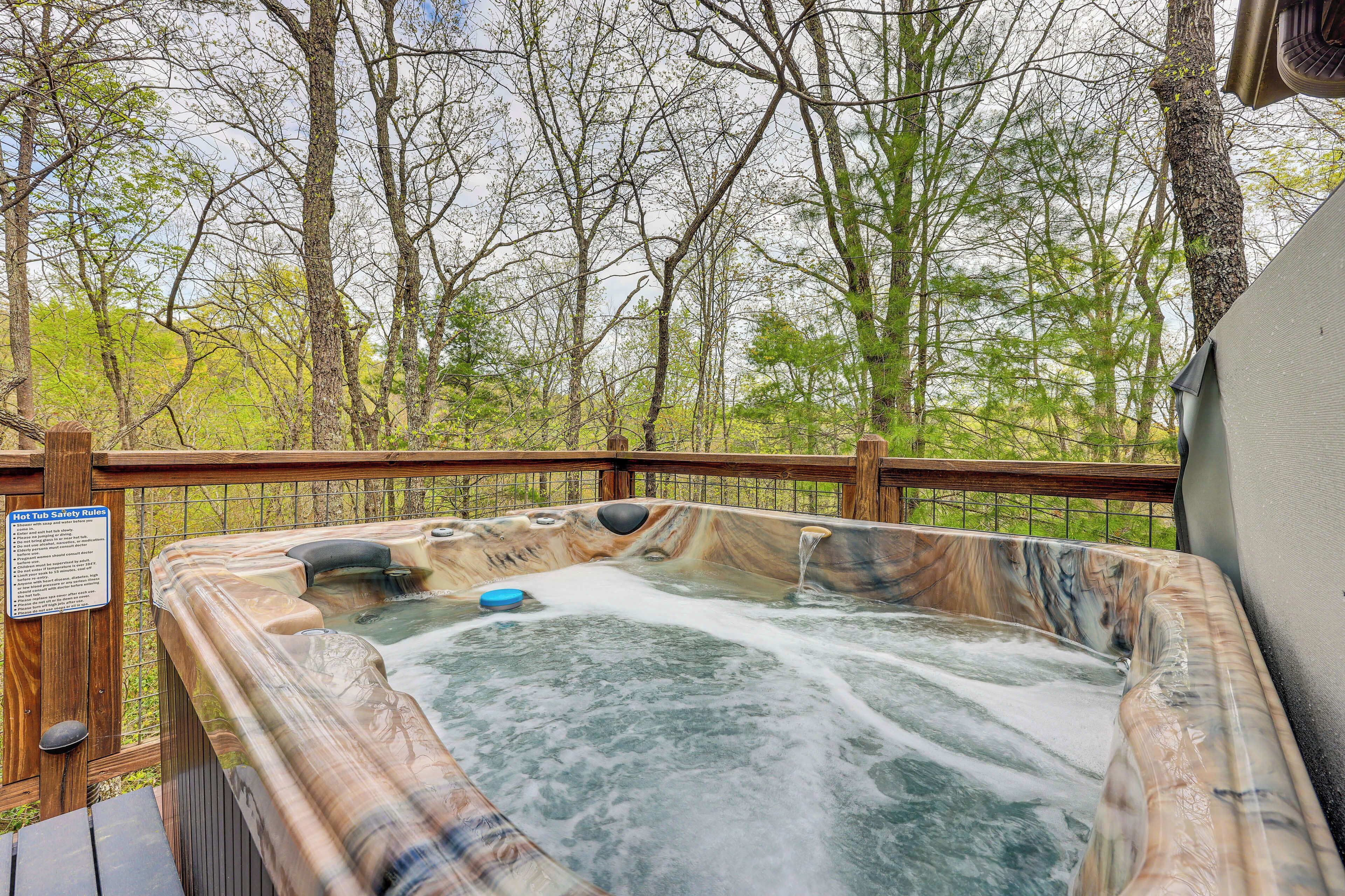A hot tub surrounded by a wooden deck with a sign indicating safety rules.