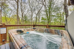 Een hottub omringd door een houten terras, met een bord waarop veiligheidsvoorschriften staan.