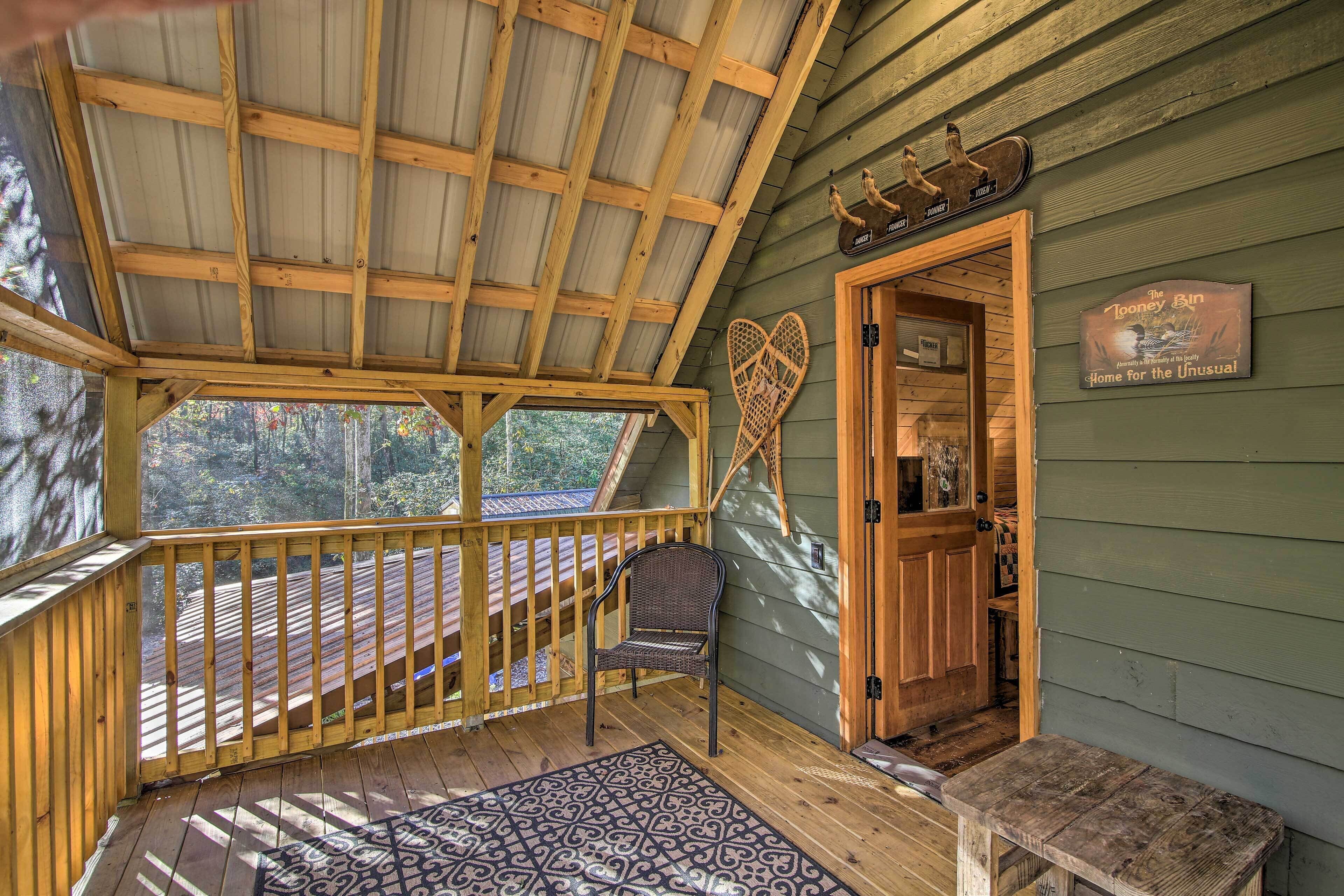A wooden deck with a covered area, a chair, and a small bench.