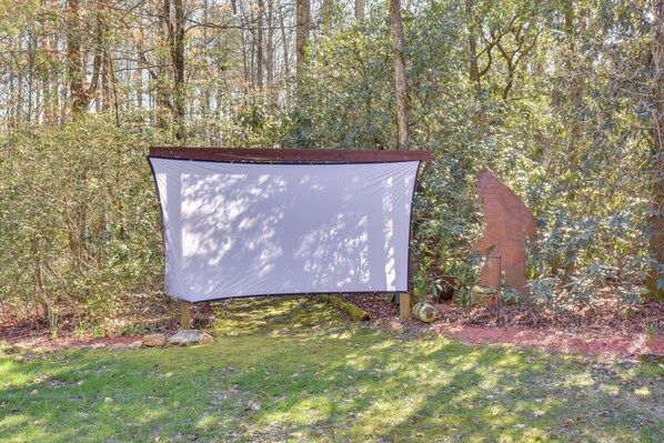A tent-like structure in a forested area with a clear path leading to it.