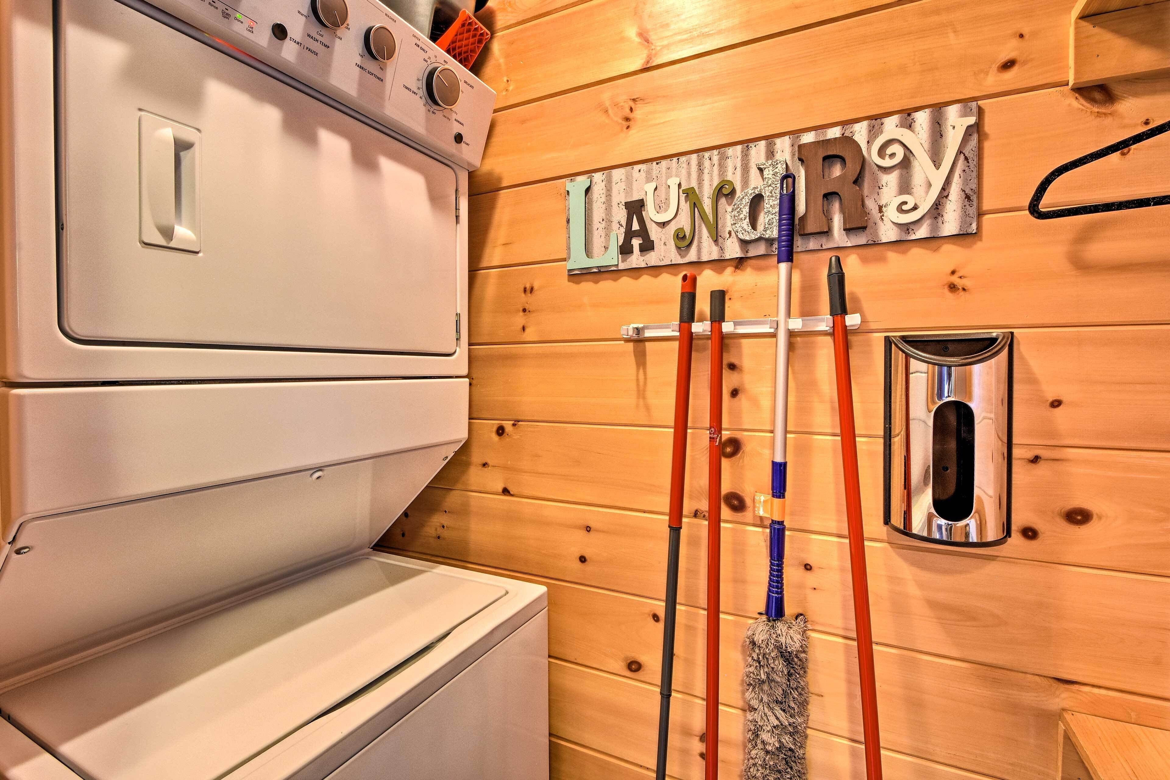 Ein Waschbereich mit Waschmaschine, Wäscheständer und einem Metallschild mit dem Wort 'Laundry'.