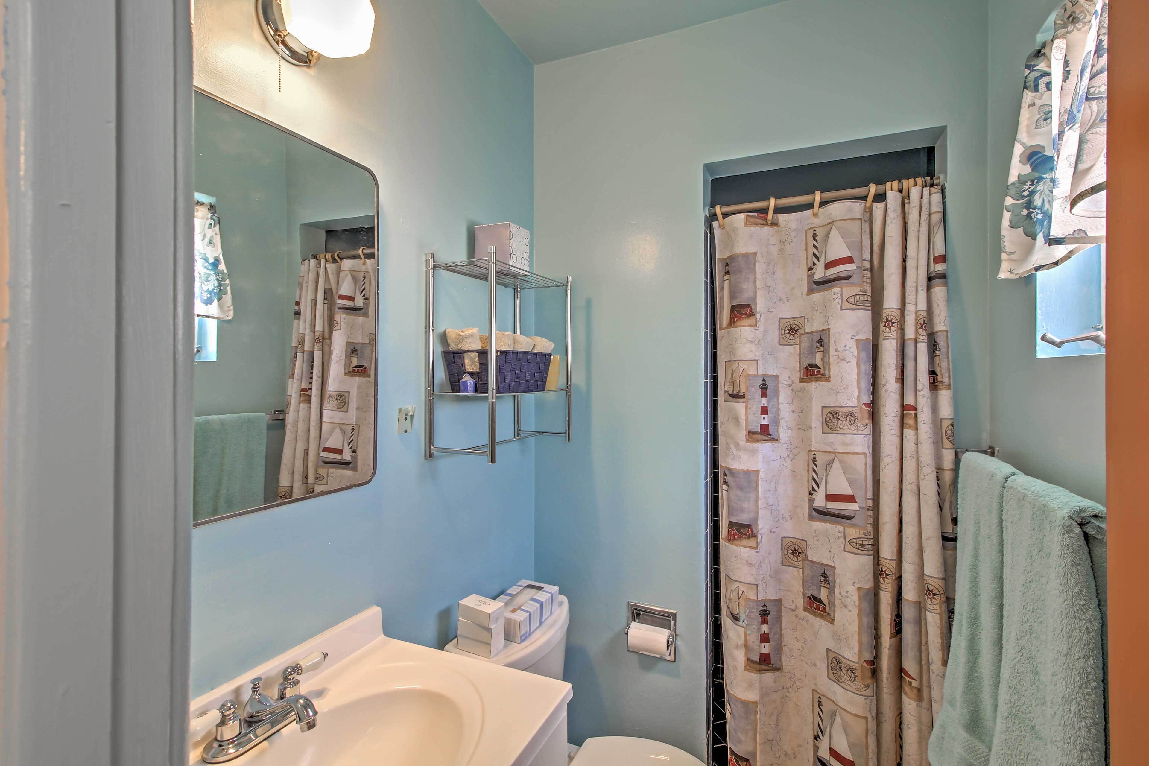 Un baño con lavamanos, inodoro y cortina de ducha.