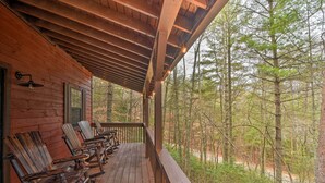 A wooden deck with chairs and a railing overlooking a forest. - Modern Cabin w/ Deck in the Blue Ridge Mountains! (Blairsville)
