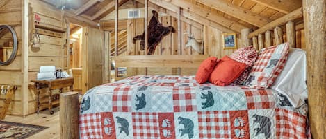 A rustic wooden room with a bed featuring a checkered quilt, a ceiling fan, and wooden beams.