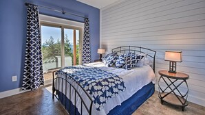 Un dormitorio con cama, mesita de noche y ventana con cortinas.
