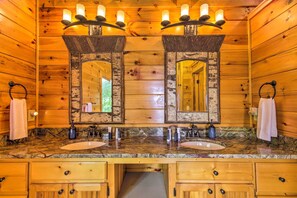 Bathroom features a double sink, granite countertop, and two large mirrors.