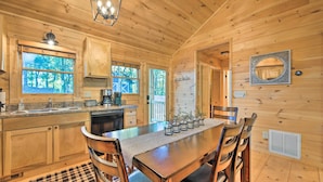 A wooden cabin interior with a kitchen, dining area, and a large window. - Blue Ridge Hideaway w/ Fire Pit & Mtn Views! (Blue Ridge)
