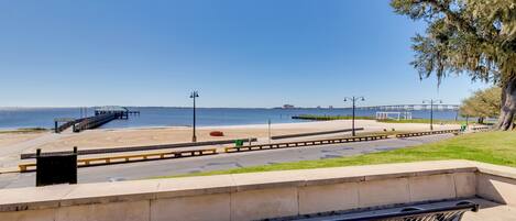 Un banco con vista a una playa y un muelle al fondo.
