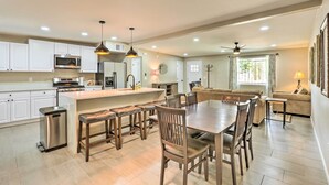 A modern kitchen with white cabinets, a central island, and bar stools. - Tucson Getaway w/ Private Pool & Gas Grill! (Tucson)