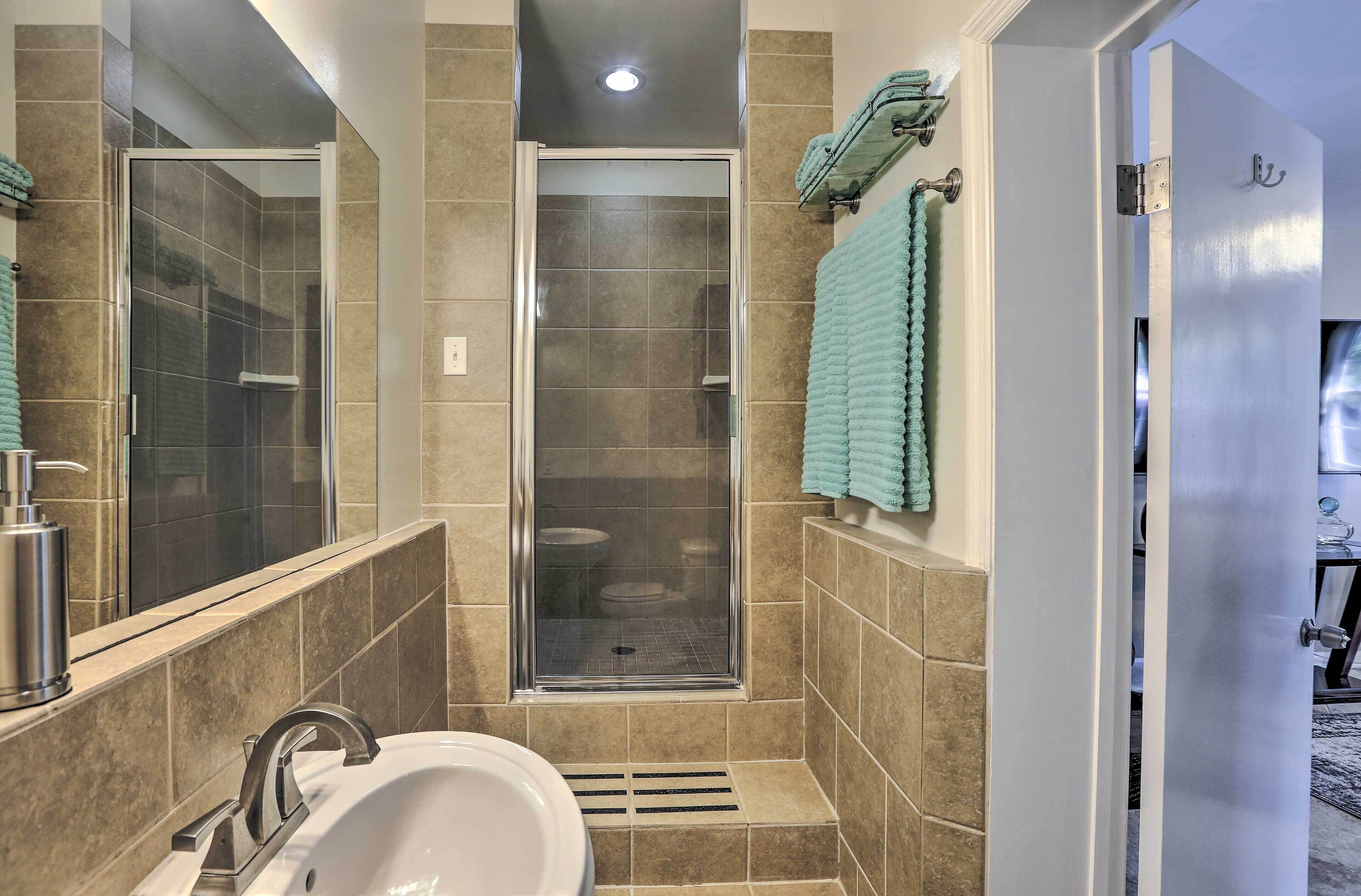 Un baño con ducha, lavamanos e inodoro.