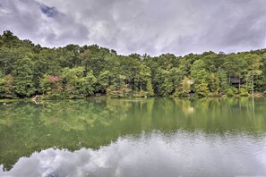 A calm lake with a forested hillside in the background.