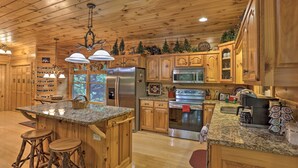 A spacious kitchen with wooden cabinets, granite countertops, and stainless steel appliances. - Cherry Lake Lodge w/ Hot Tub, Fire Pit & Game Room (Blue Ridge)