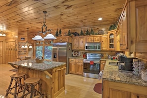 A spacious kitchen with wooden cabinets, granite countertops, and stainless steel appliances. - Cherry Lake Lodge w/ Hot Tub, Fire Pit & Game Room (Blue Ridge)