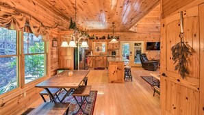 A wooden cabin interior with a dining area, kitchen, and living space. - Cherry Lake Lodge w/ Hot Tub, Fire Pit & Game Room (Blue Ridge)