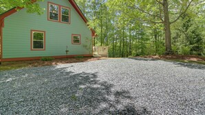 A green house with a gravel driveway and a wooden fence. - Blue Ridge Getaway w/ Hot Tub & Seasonal View! (Blue Ridge)