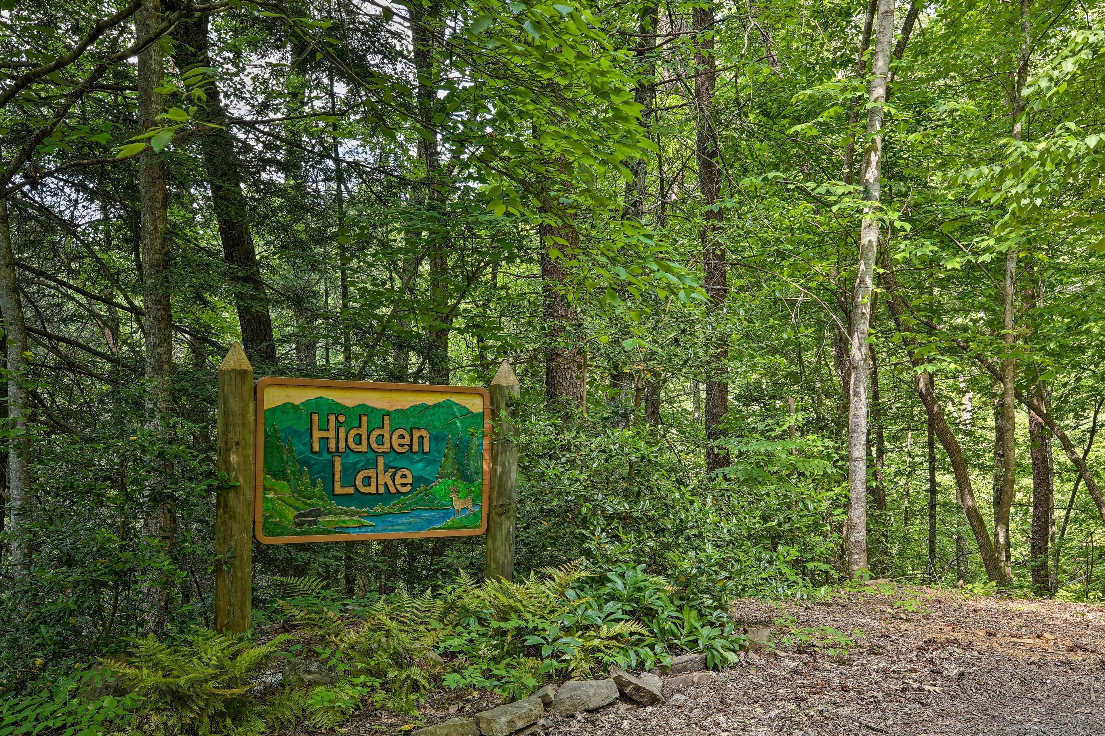 A sign for Hidden Lake surrounded by dense forest.