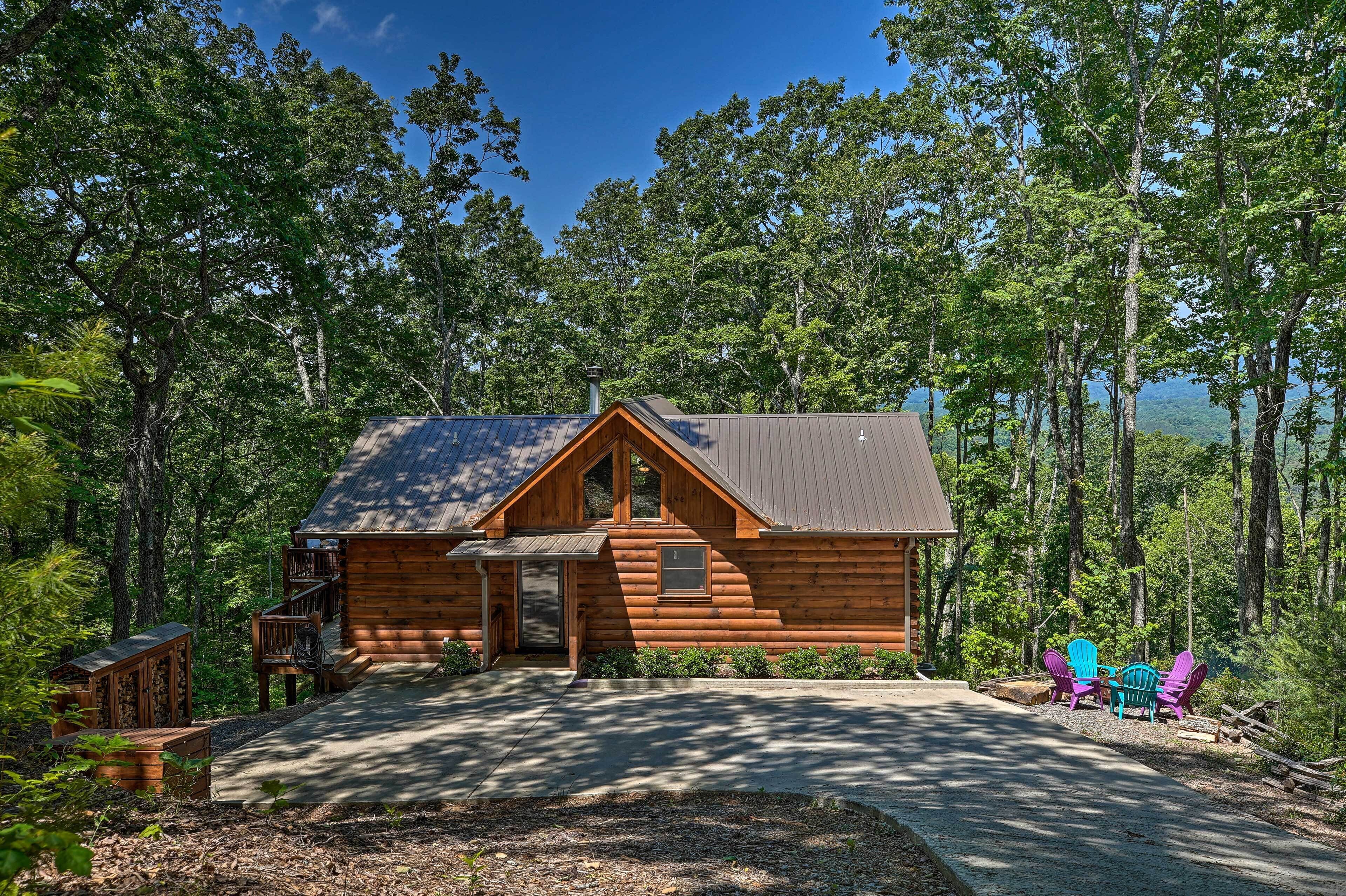 A log cabin with a porch, surrounded by trees and a clear sky.