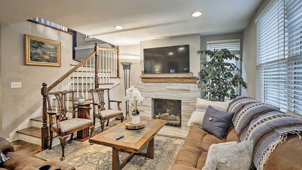 A living room with a fireplace, a staircase, and a large window with blinds. - Nashville Home w/ Fire Pit & Yard, 3 Mi to Dwtn (Nashville)