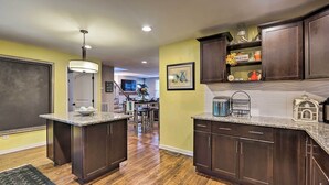 A kitchen with dark wood cabinets, granite countertops, and a central island. - Nashville Home w/ Fire Pit & Yard, 3 Mi to Dwtn (Nashville)