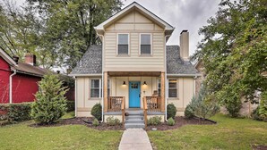 A two-story house with a front porch, a blue door, and a small staircase leading to the entrance. - Nashville Home w/ Fire Pit & Yard, 3 Mi to Dwtn (Nashville)