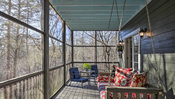A covered porch with a wooden floor, two blue chairs, a small table, and a colorful sofa. - Cozy & Quiet Studio w/ Porch, Near Scenic Railway! (Blue Ridge)