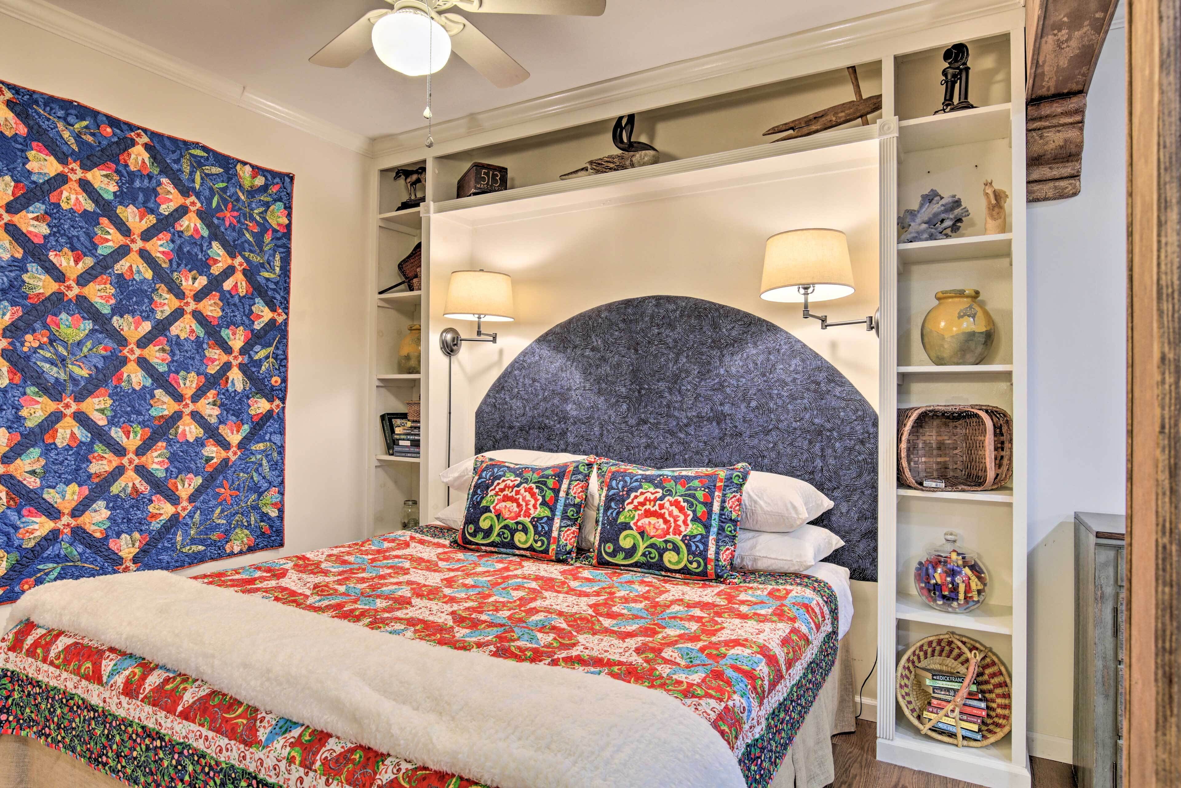Une chambre à coucher avec un grand lit, une tête de lit et une bibliothèque intégrée agrémentée d’objets décoratifs.