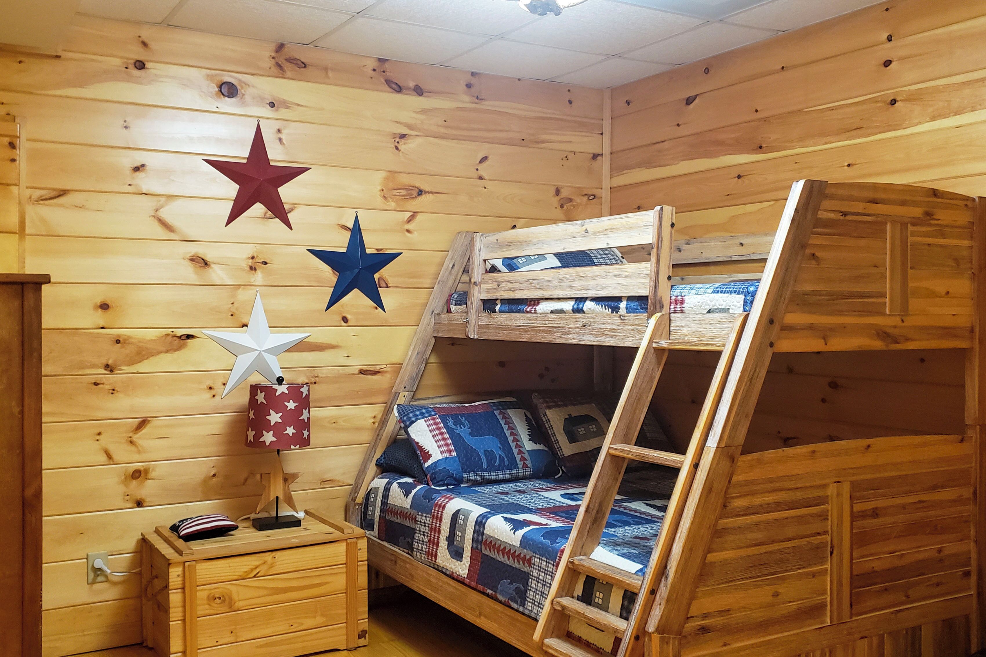 Une chambre avec un lit superposé, des murs en bois, une décoration sur le thème des étoiles et une petite table de chevet.