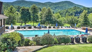 A swimming pool with lounge chairs and umbrellas, surrounded by lush greenery and hills. - Sky Valley Retreat w/ Resort Amenities & Views! (Dillard)