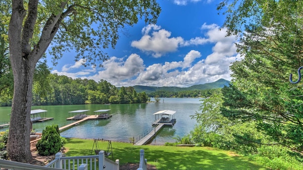 A lakeside property with docked boats, a gazebo, and a well-maintained lawn.
