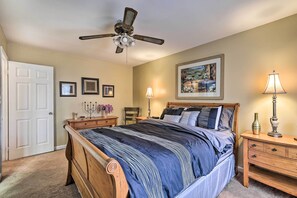 A bedroom with a bed, a ceiling fan, a nightstand, a lamp, and framed pictures on the wall. - Family Home Near Panola Mountain State Park! (Lithonia)