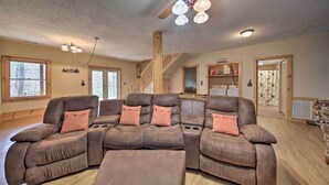 A spacious living room with a large sectional sofa, a ceiling fan, and a kitchen area in the background. - Cozy Blue Ridge Cabin w/ Sauna & Trail Access! (Blue Ridge)