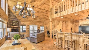 A spacious log cabin interior with a dining area, living room, kitchen, and a loft bedroom. - Cozy Blue Ridge Cabin w/ Sauna & Trail Access! (Blue Ridge)