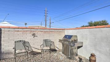 Enjoy al fresco dining on the patio, where a barbecue grill and two chairs await.