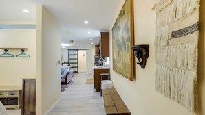 Un corridoio con una panca in legno, un arazzo appeso al muro e un appendiabiti.