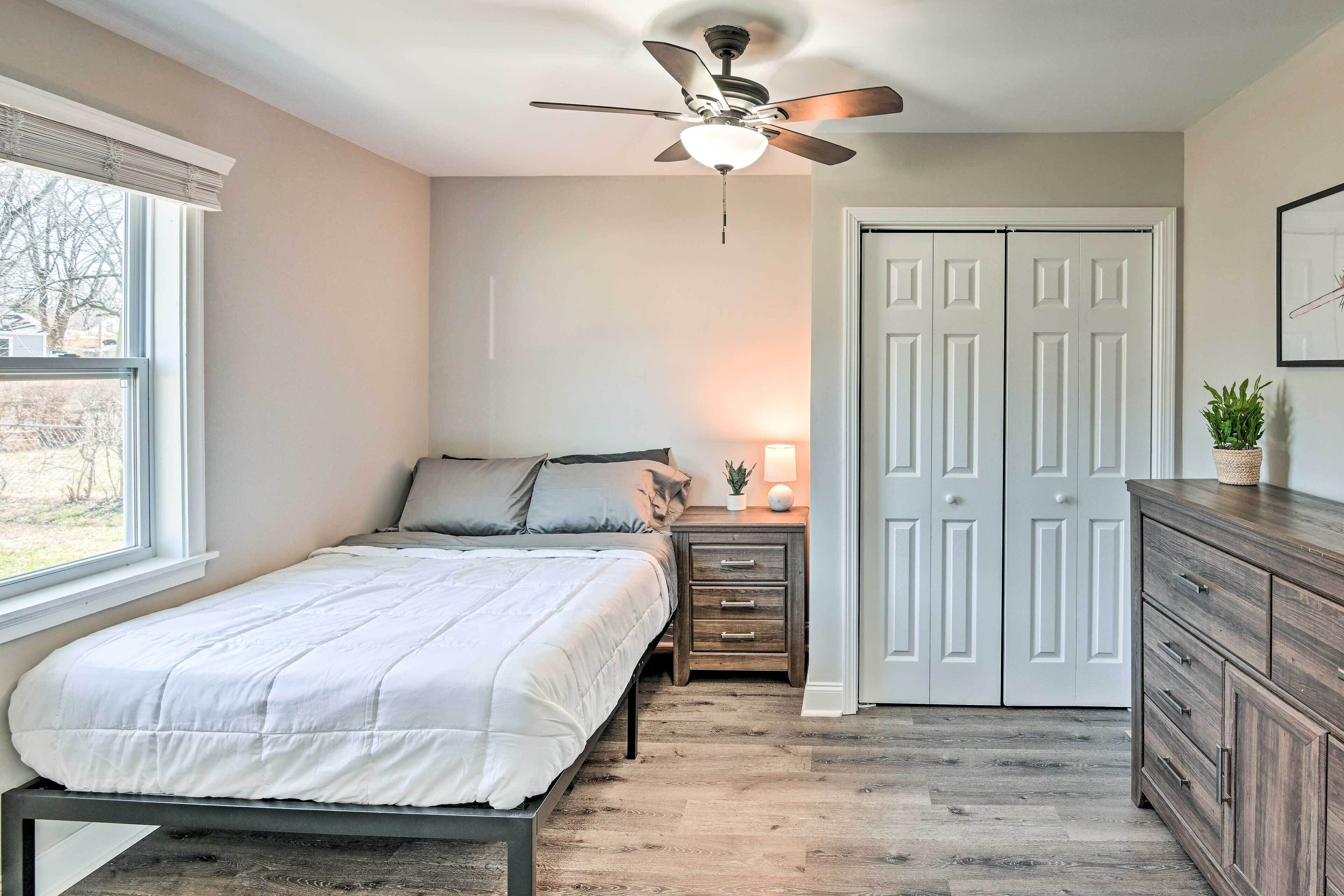 A bedroom with a bed, bedside table, lamp, and wardrobe.