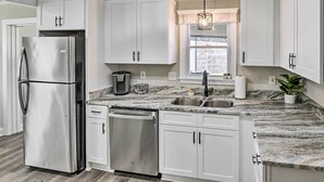 A modern kitchen with white cabinets, stainless steel appliances, a marble countertop, and a window with a view. - ~ 7 Mi to Downtown! Nashville Home Rental (Nashville)