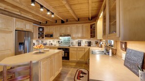 Une cuisine spacieuse dotée de meubles en bois, d’appareils électroménagers en acier inoxydable et d’un îlot central.