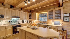 Une cuisine spacieuse avec des meubles en bois, un îlot central et une grande fenêtre.