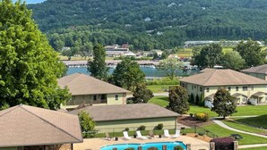 Un quartier résidentiel avec des maisons, une piscine et un lac en arrière-plan.