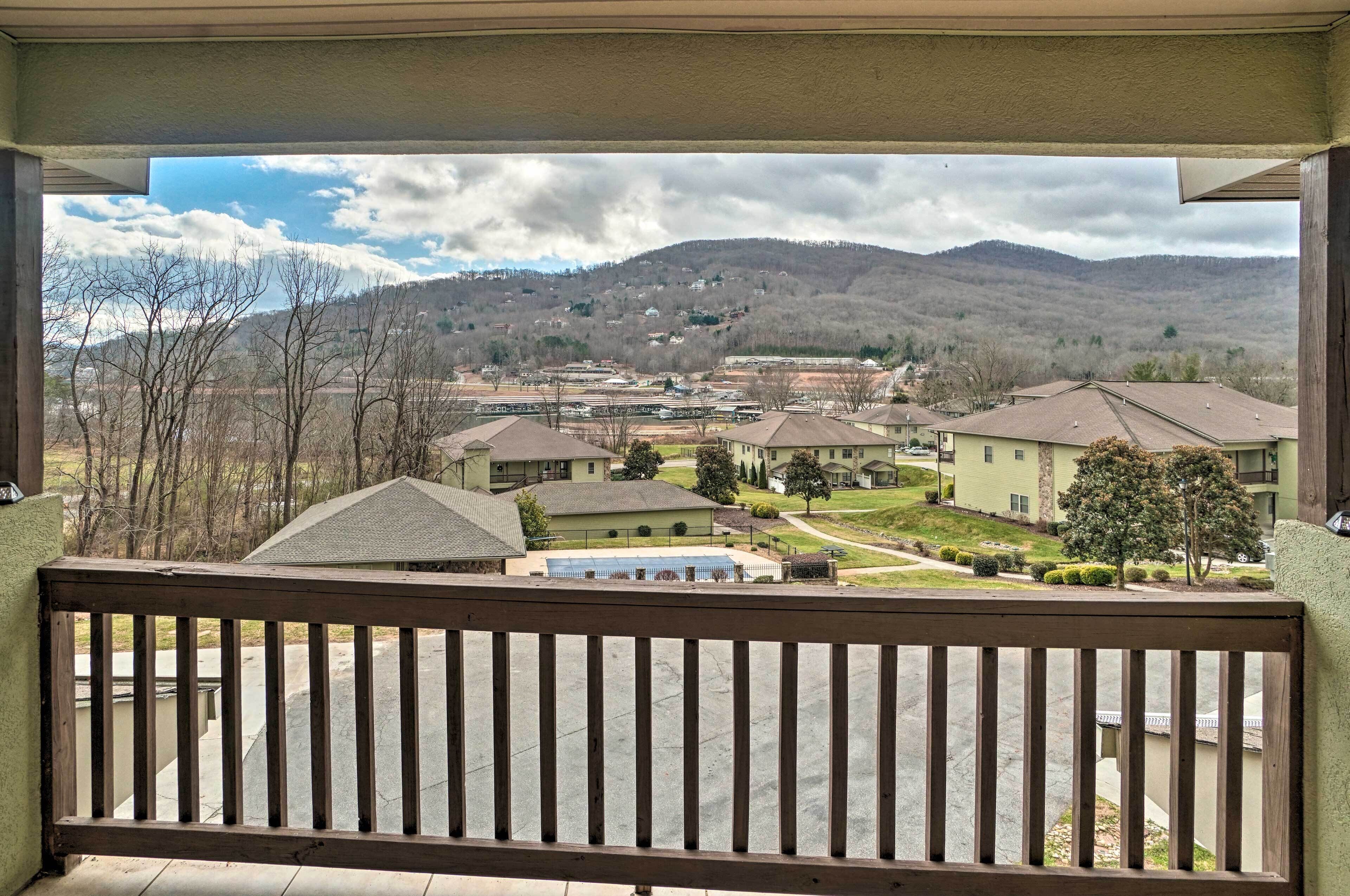 A residential area with houses, a green building, and a mountain in the background.