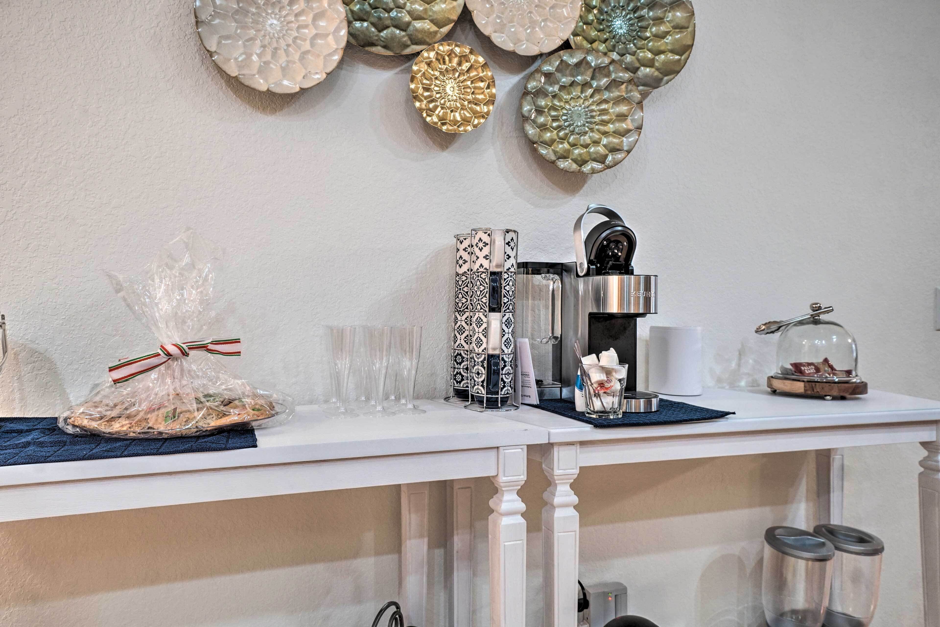 A kitchen counter with a coffee maker, glasses, and decorative plates.