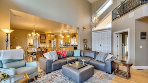 A spacious living room with a sectional sofa, a coffee table, and a dining area in the background. - Sky Valley Home w/ Mtn View, 5 Mi to Rabun Bald! (Dillard)
