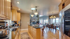 A modern kitchen with wooden cabinets, stainless steel appliances, and a central island. - Sky Valley Home w/ Mtn View, 5 Mi to Rabun Bald! (Dillard)