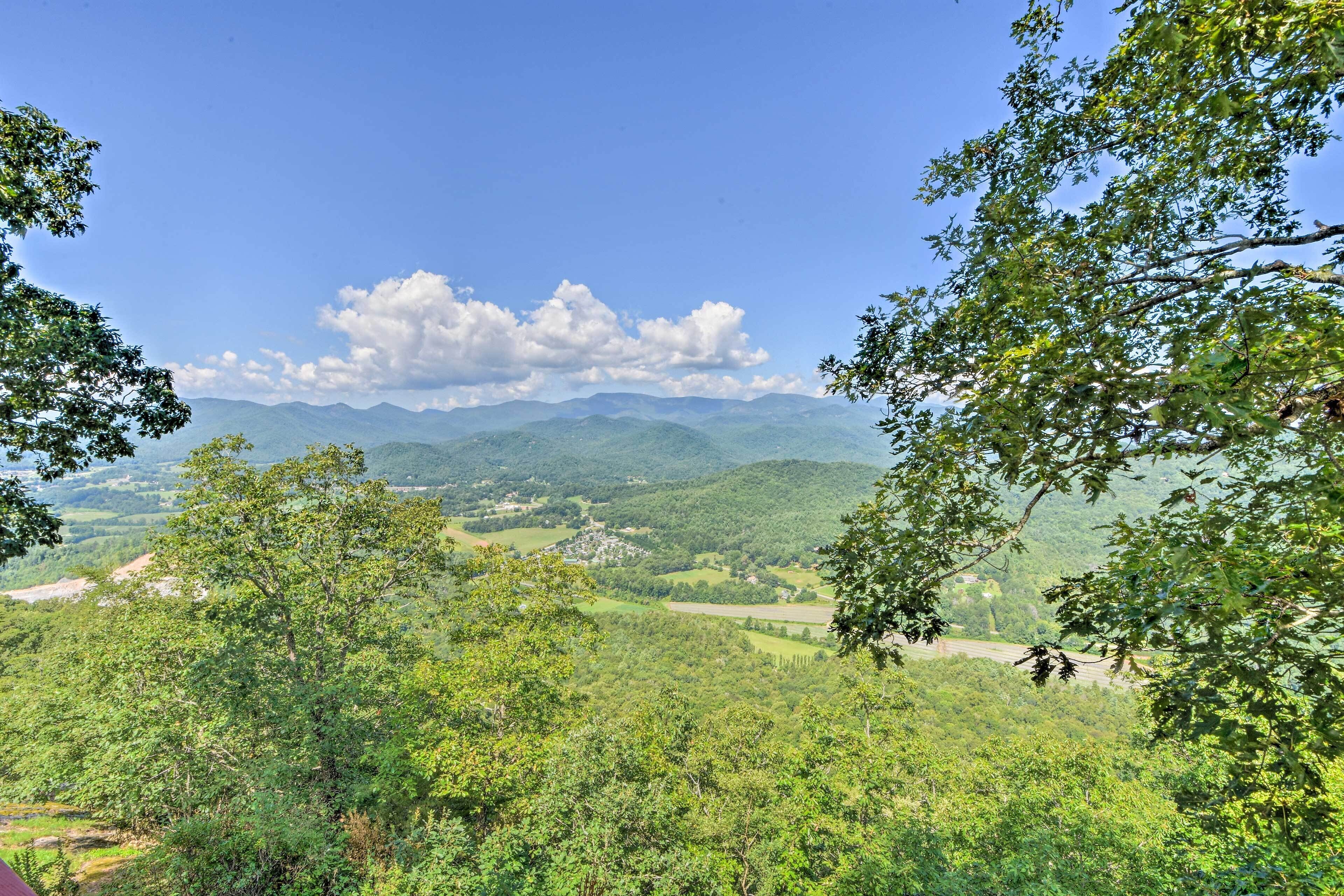 Eine gebirgige Landschaft mit dichtem Grün und blauem Himmel.