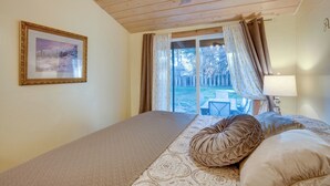 A bedroom with a large bed, a framed picture on the wall, and a view of the outdoors through a window. - Tahoe Home 3 Mi to Heavenly Mountain Resort! (Stateline)
