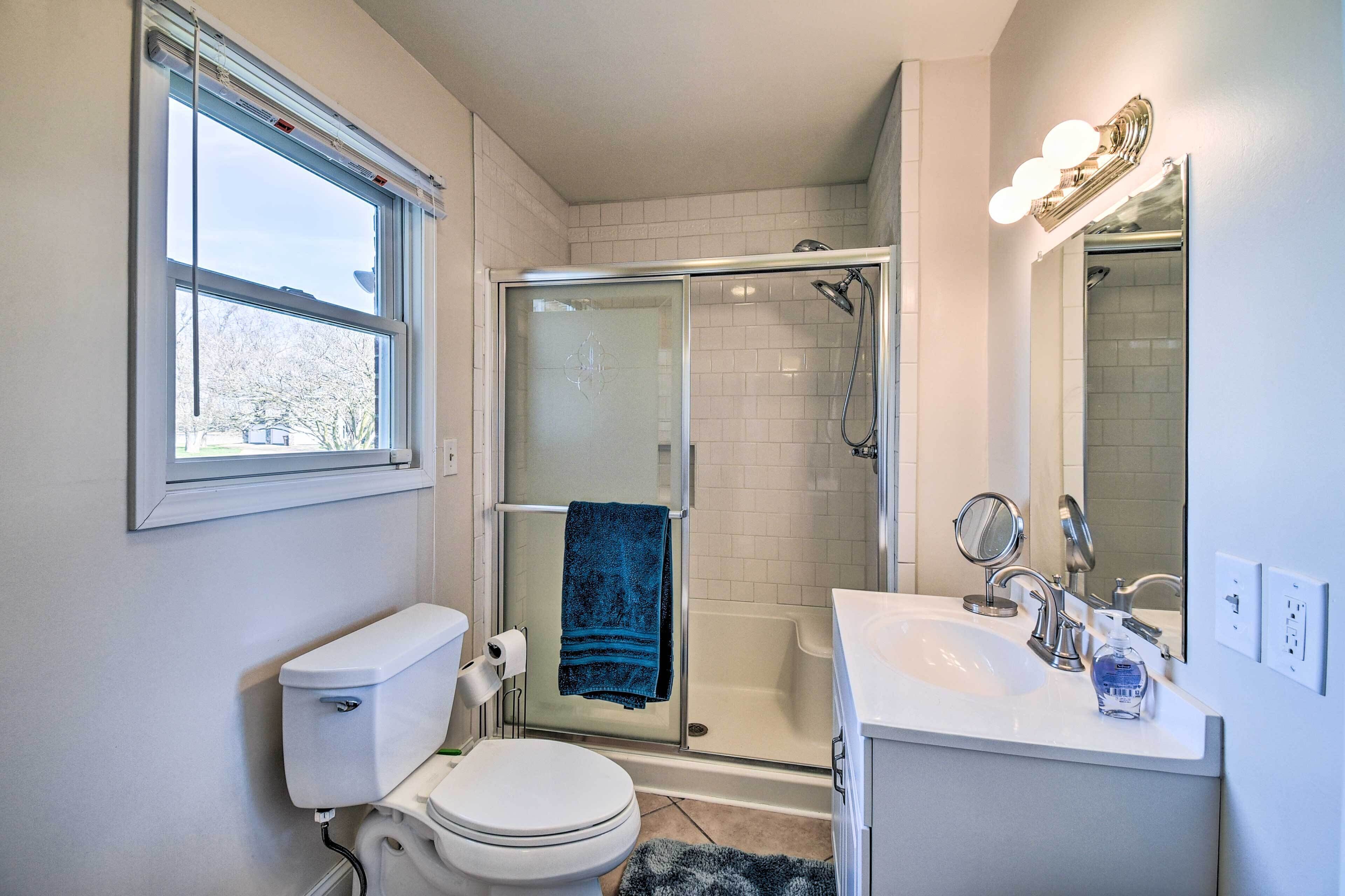 A modern bathroom with a toilet, sink, and shower.