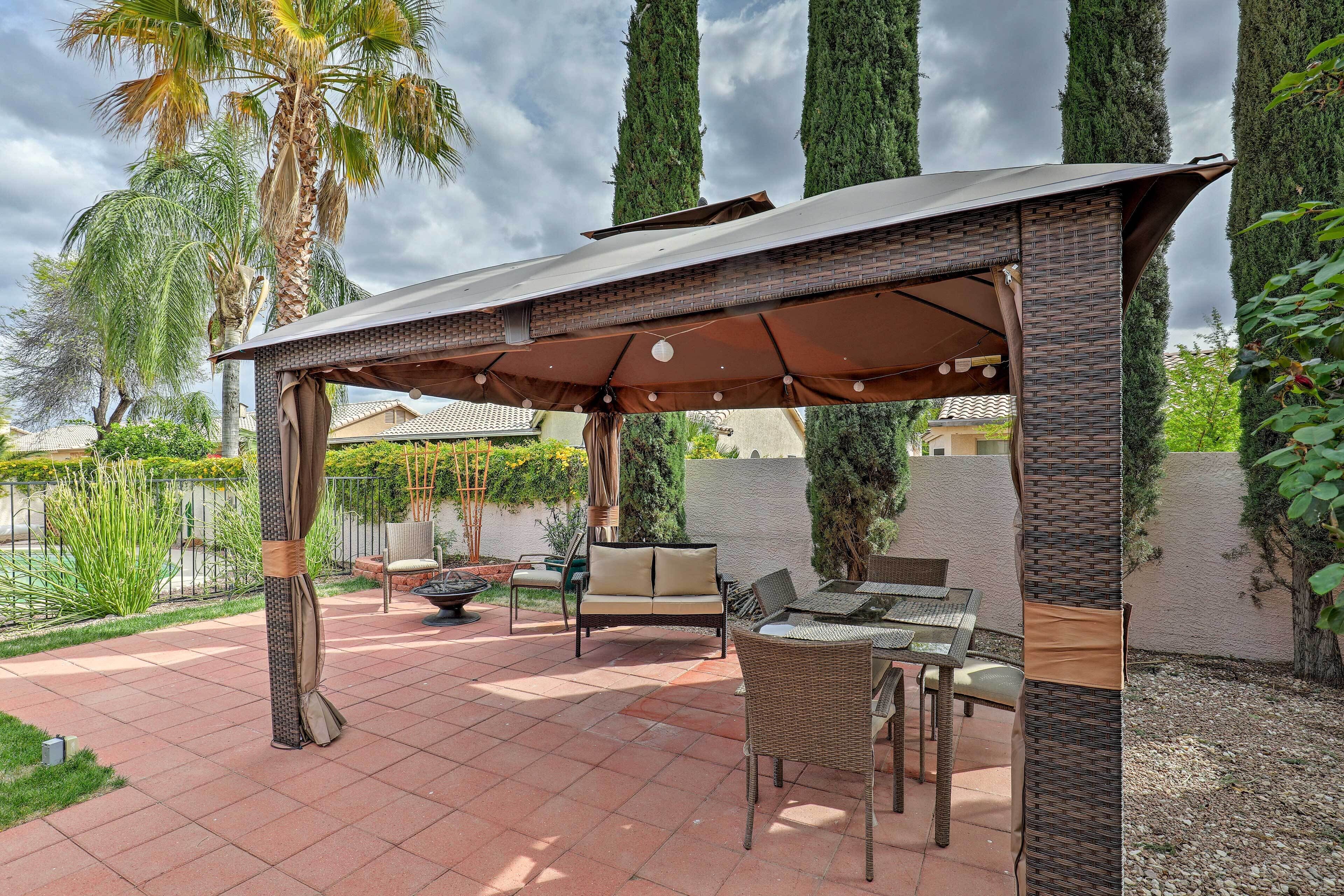A covered patio area with a table and chairs, a sofa, and a pergola structure.