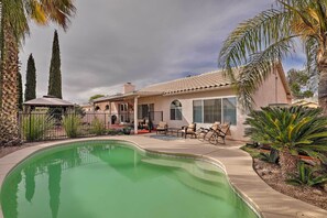 A residential property with a swimming pool, patio furniture, and palm trees. - Tucson Getaway w/ Yard, Pool, Hot Tub + Gas Grill! (Tucson)