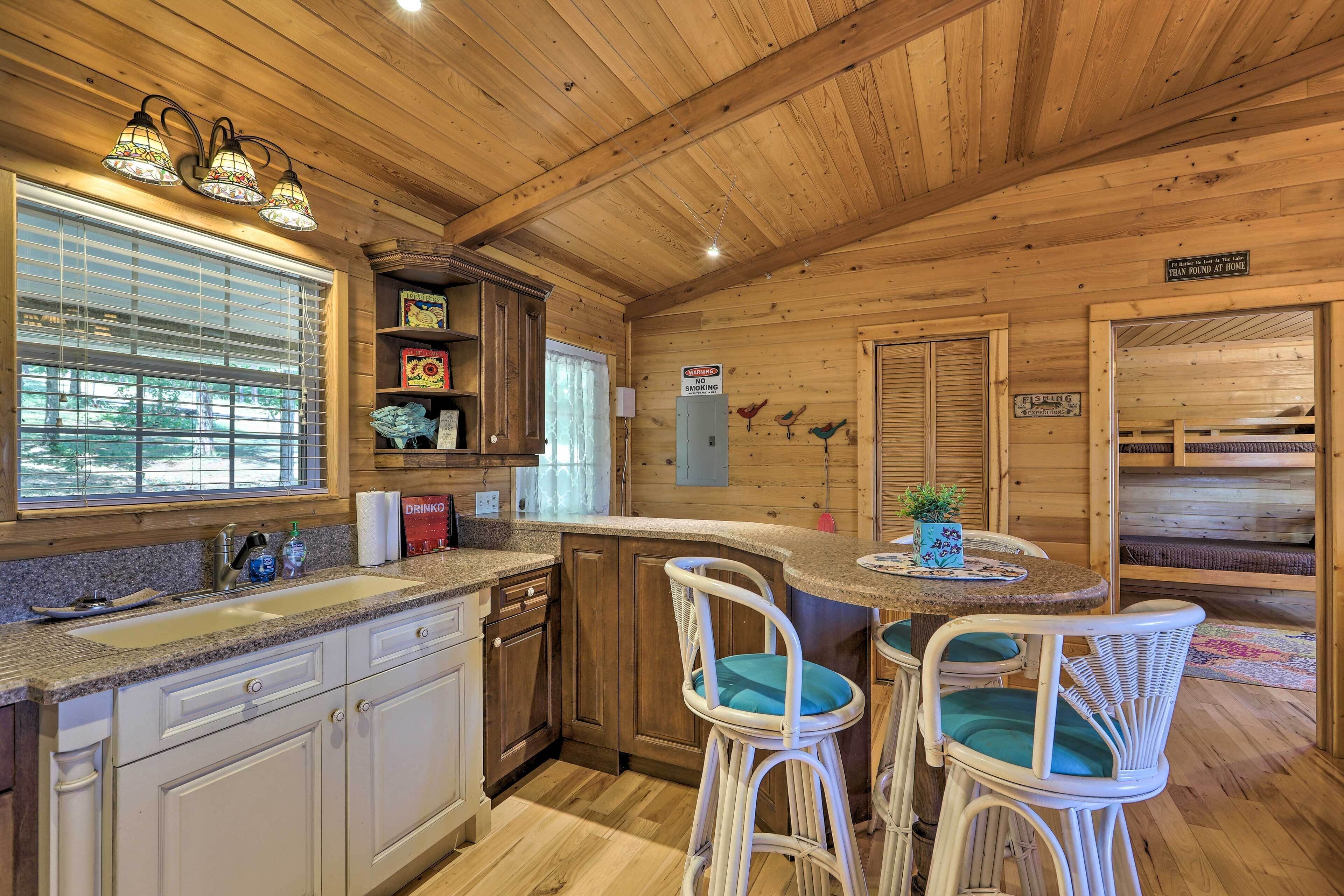 Interno di una baita di legno con angolo cottura, zona pranzo e un cartello che indica 'No Smoking'.